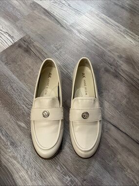 Anne Klein Ivory Leather Slip-On Loafers with Metal Emblem